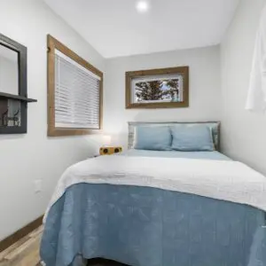 Bedroom with a bed, dresser, mirror, and towel rack