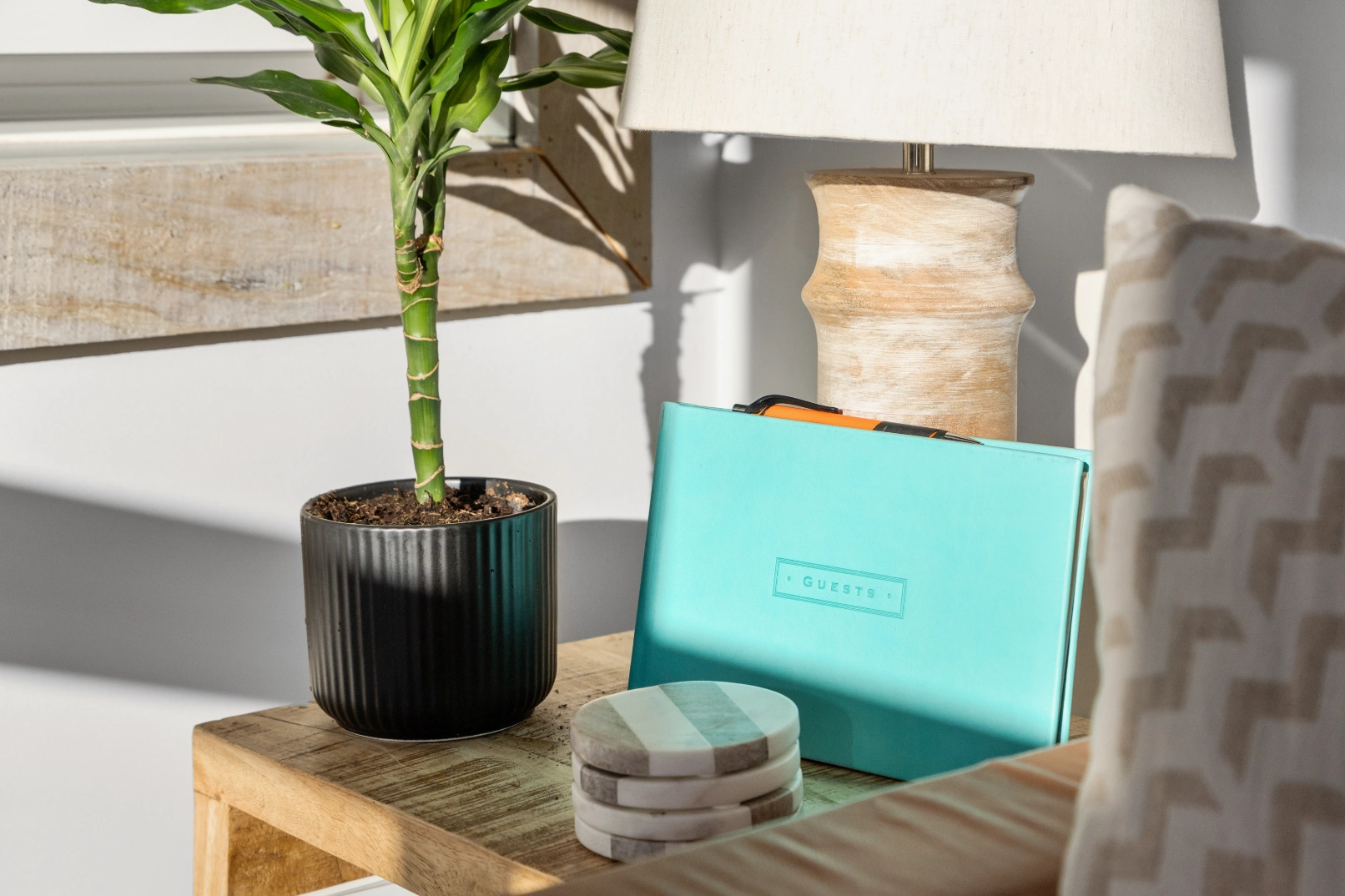 Guest book, plant, lamp on wood table