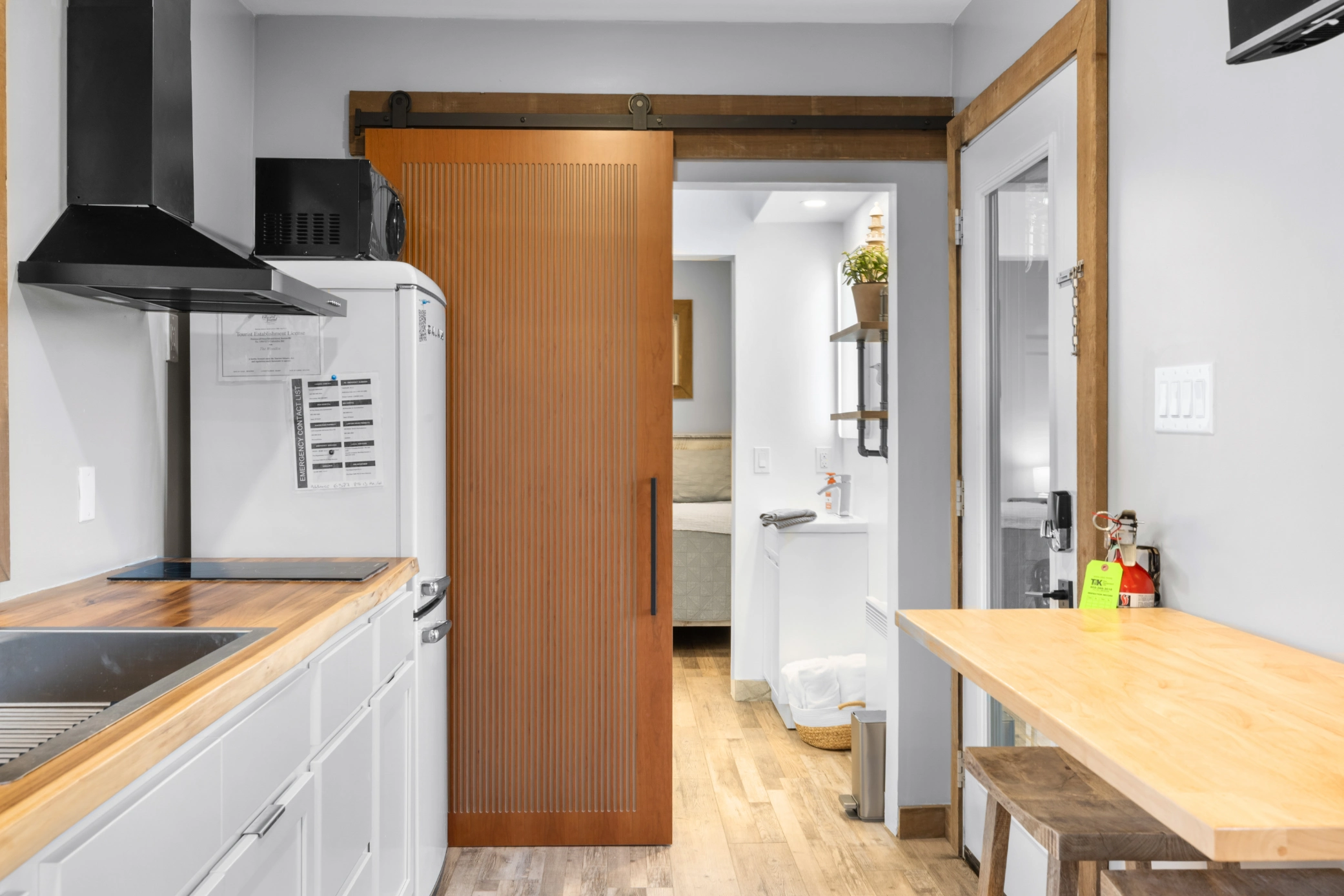 Stylish small kitchen with wood counters and white cabinets