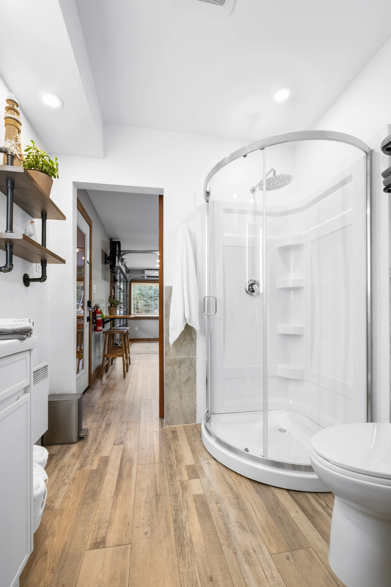 White bathroom with industrial shelves and plant