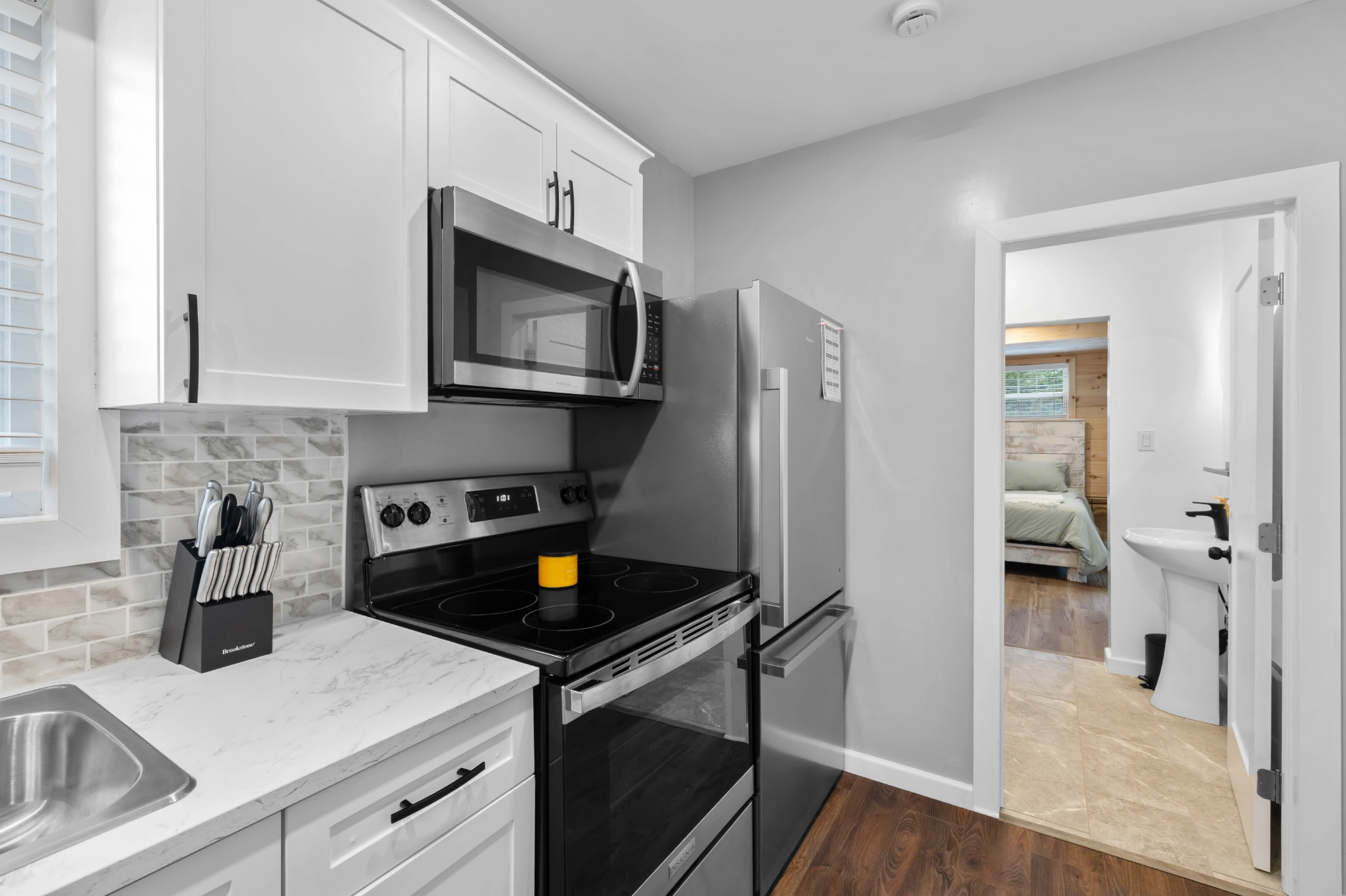 Clean kitchen with bedroom and bathroom view