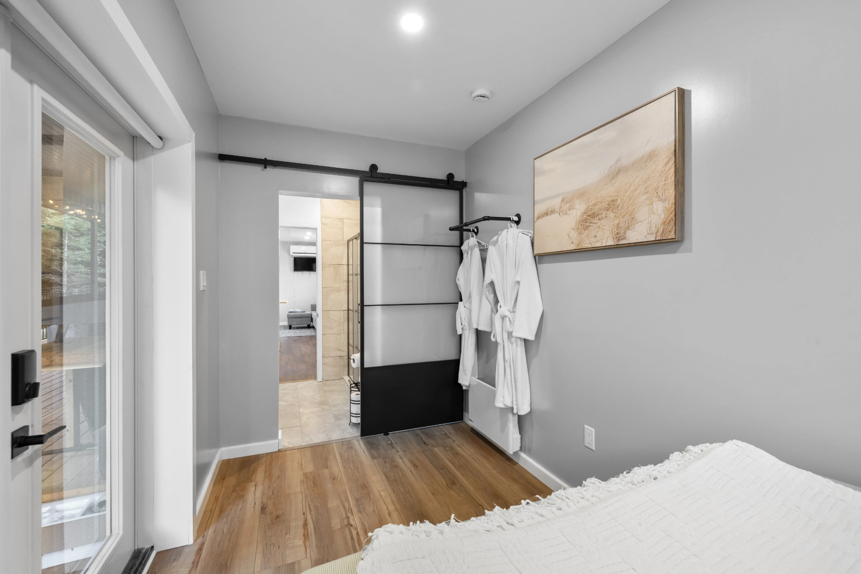 Bedroom with barn door, robes, and beach art