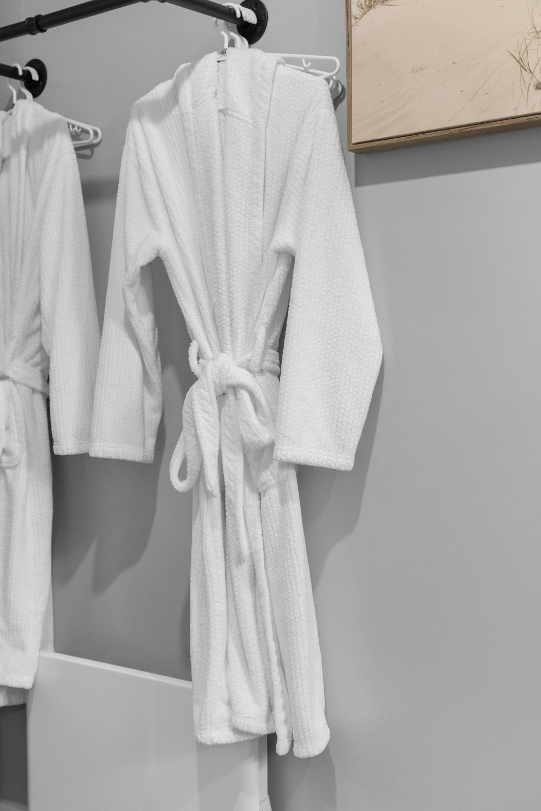 Soft white hotel bathrobes hanging ready