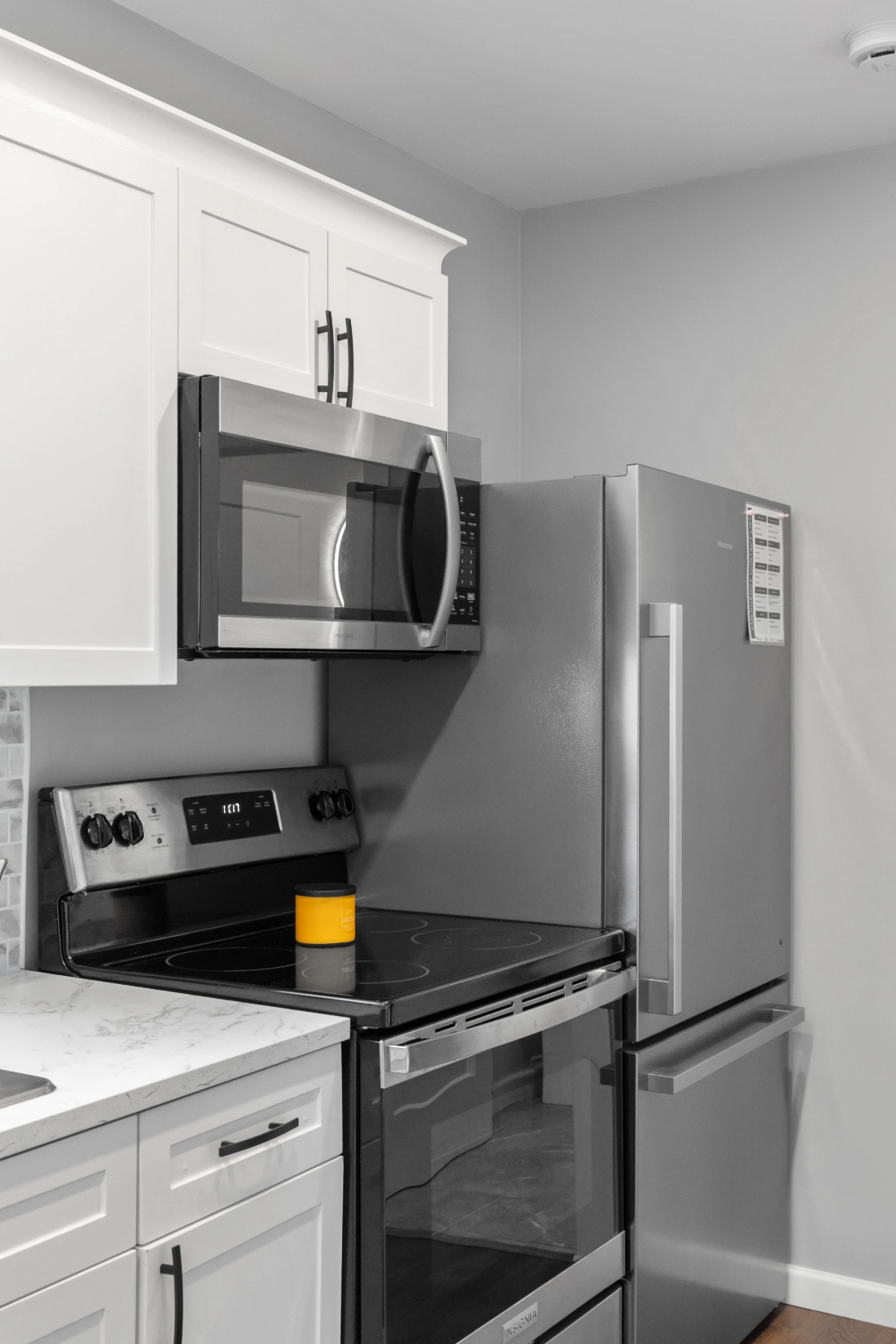 Sleek white cabinets, microwave, range, refrigerator